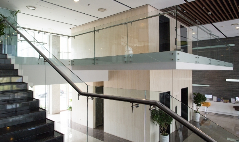 : Glass staircase railing with spigot mounts and top rail finish